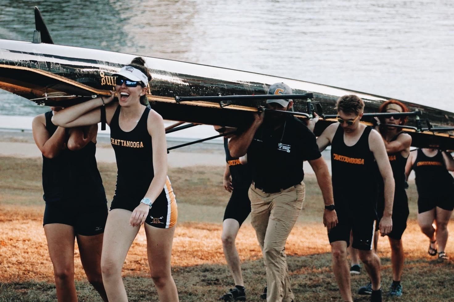 UTC women's squad carrying an eight overhead down to the water, Worth era.