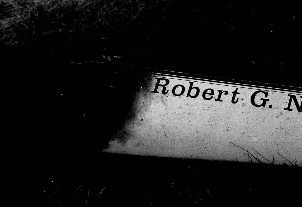 Close-up of a charred boat nameplate reading 'Robert G. N…' — the rest is destroyed by fire.