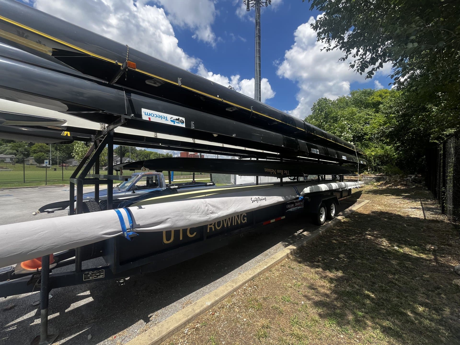 UTC Rowing's team trailer, parked outside with rowing shells stacked on it