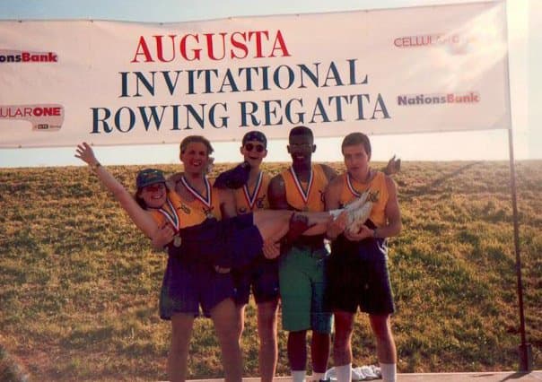 Augusta Invitational Rowing Regatta medal podium — five UTC athletes in yellow kit, NationsBank + CellularOne sponsor banner overhead