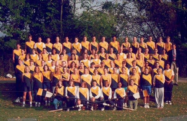 Full UTC Rowing team photo — approximately 60 rowers in yellow/black uniforms with oars laid in front